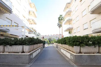 a walkway between two buildings with potted plants at Ático con piscina en excelente urbanización by Hometels in Canet de Berenguer