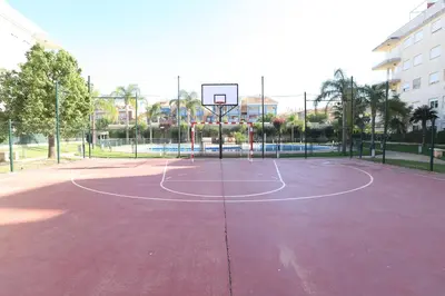 a basketball court with a hoop in a park at Ático con piscina en excelente urbanización by Hometels in Canet de Berenguer