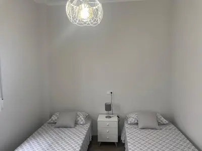 a bedroom with two beds and a chandelier at Maison Sereine in Valencia