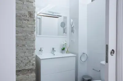 a white bathroom with a sink and a mirror at SingularStays Mercado Central in Valencia