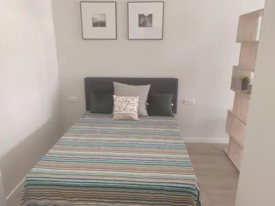 a bed with a striped mattress in a room at Apartamento moderno de 70 metros a 300 metros de la playa in Valencia