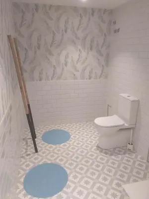 a bathroom with a toilet and blue mats on the floor at Apartamento moderno de 70 metros a 300 metros de la playa in Valencia