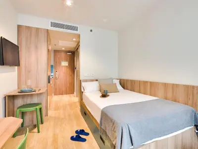 a bedroom with a bed and a table and a chair at Livensa Living Studios Valencia Viveros Hotel - Apartamento in Valencia