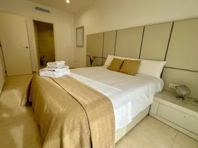 a bedroom with a large bed with white sheets at Reinapart Patacona Beach 40 in Valencia