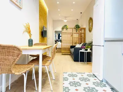 a kitchen and living room with a table and chairs at FLORIT FLATS - The Cabanyal & Port Suites in Valencia