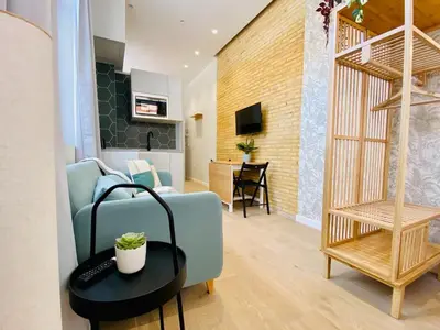 a living room with a blue couch and a table at FLORIT FLATS - The Cabanyal & Port Suites in Valencia