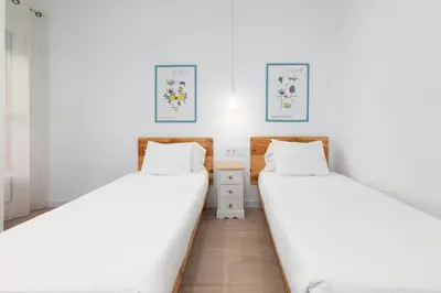 two beds in a room with white walls at ApartUP Valencia Opera in Valencia