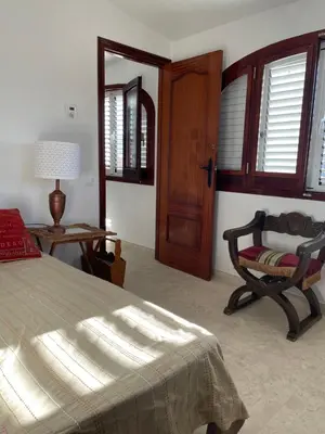 a bedroom with a bed and a chair and a table at Chalet Las Brisas in Cullera
