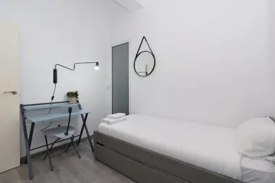 a bedroom with a bed and a desk with a mirror at GuestReady - El Cabanyal Hidden Oasis in Valencia