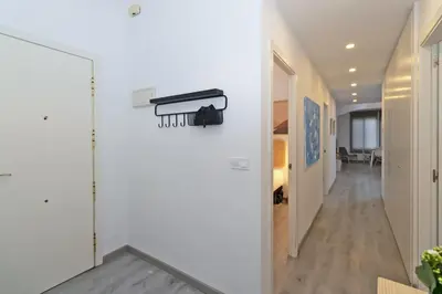 a hallway with a white wall with a black rack on it at GuestReady - El Cabanyal Hidden Oasis in Valencia