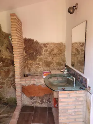 a stone bathroom with a sink and a mirror at Trocito de Paraíso en la Sierra Espadán in Eslida