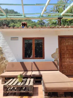 a patio with two benches and a window at Trocito de Paraíso en la Sierra Espadán in Eslida