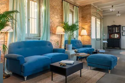 a living room with blue couches and a table at Maison Muralleta B&B in Riba-Roja De Turia