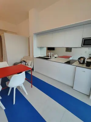a kitchen with a red table and white cabinets at CariSan1 - 6 min to beach, modern, bright in Valencia