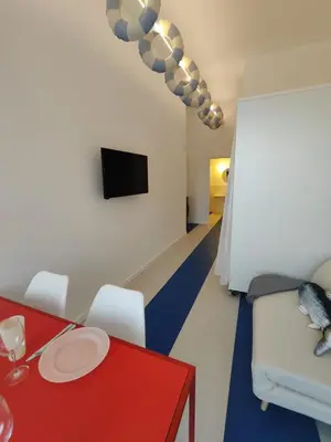 a living room with a red table and white chairs at CariSan1 - 6 min to beach, modern, bright in Valencia