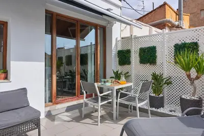 a patio with a table and chairs on a balcony at Sunny Cozy Penthouse with a Terrace at Plaza del Carmen in Valencia