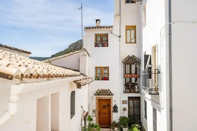 a white building with a brown door and windows at Casa la Baronia in Chulilla