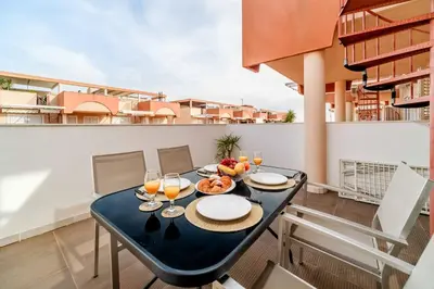 a dining table on the balcony of a apartment at Ático Balinés con vistas al mar in Canet de Berenguer