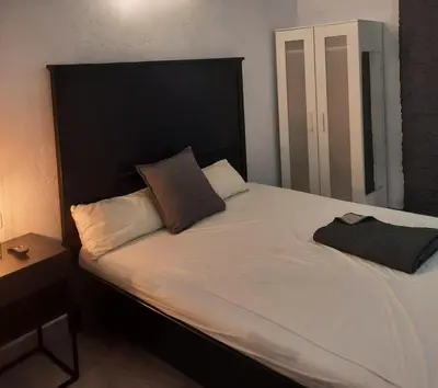 a bed with a black headboard and two pillows at Bonito Alojamiento F in Valencia