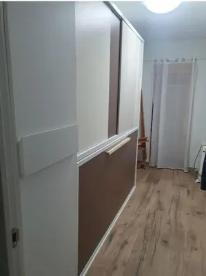 a kitchen with white cabinets and a wooden floor at Apartamento primerísima línea in Port Saplaya