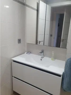 a white bathroom with a sink and a mirror at Apartamento primerísima línea in Port Saplaya