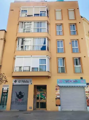 a tall yellow building with a sign in front of it at A studio-apartment in a newly built house.WIFI in Valencia