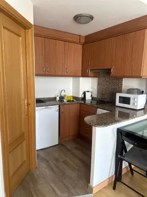 a kitchen with white appliances and wooden cabinets at A studio-apartment in a newly built house.WIFI in Valencia