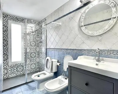 a bathroom with a sink and a toilet and a mirror at Apartamento con Terraza cerca de la Estación del Nord in Valencia