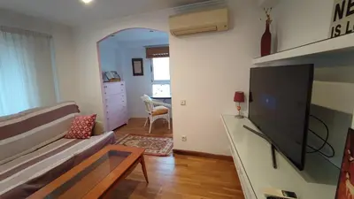 a living room with a couch and a flat screen tv at Precioso apartamento a 7 minutos en tren al centro de Valencia in Benetúser