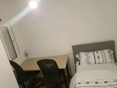 a small room with a bed and a desk and a bed at vip rooms patraix in Valencia