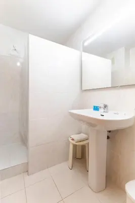 a white bathroom with a sink and a shower at Travel Habitat Port Saplaya con vistas al Mar in Port Saplaya