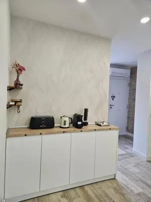 a kitchen with white cabinets and a wall at Habitación céntrica de Lujo Gv 1 in Valencia
