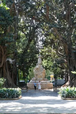 two people walking in front of a statue in a park at Habitación céntrica de Lujo Gv 2 in Valencia