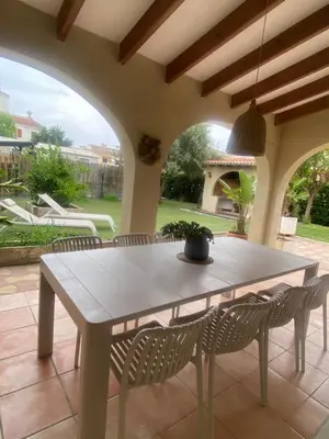 a table and chairs on a patio with a table and a potted plant at La casa de bega de mar in Sueca