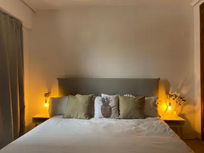a bedroom with a large white bed with two lamps at La casa de bega de mar in Sueca