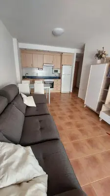 a living room with a couch and a kitchen at Ático dúplex con vistas in Canet de Berenguer
