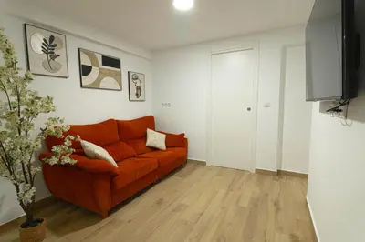 a living room with a orange couch and a television at ¡A disfrutar de Valencia! in Valencia