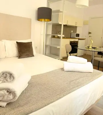 a bedroom with a large bed with towels on it at Valencia Bella Flats in Valencia