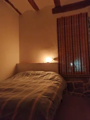 a bedroom with a bed and a window with a lamp at kats chulilla in Chulilla