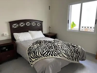 a bedroom with a zebra print bed with a window at Casa mediterránea junto al mar. in Chilches