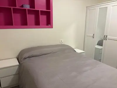 a bedroom with a bed and a pink cabinet at Casa mediterránea junto al mar. in Chilches