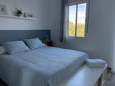 a white bedroom with a large bed with a window at Apartamento El Castell in Alaquas