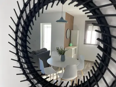 a table and chairs in a living room with a mirror at Apartamento El Castell in Alaquas