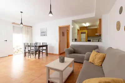 a living room with a couch and a table at Global Vacacional, Práctico apartamento con piscina en la playa de Canet in Canet de Berenguer