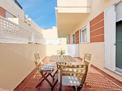 a patio with a table and chairs on a balcony at Global Vacacional, Práctico apartamento con piscina en la playa de Canet in Canet de Berenguer
