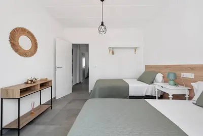 a white bedroom with two beds and a table at Bombonera 2 Jacuzzi in Catadau