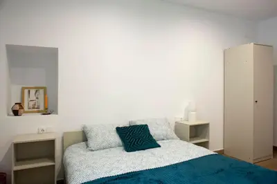 a bedroom with a bed with a blue pillow on it at Casa Rural Ana Maria Ain in Ahín
