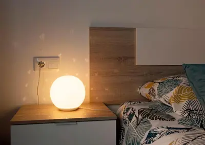 a lamp sitting on a table next to a bed at Casa Rural Ana Maria Ain in Ahín