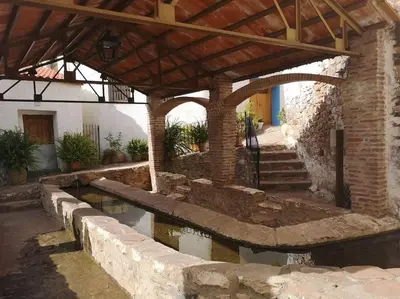 a building with a pool of water in a courtyard at Casa Rural Ana Maria Ain in Ahín
