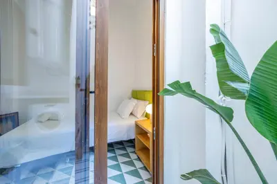 a bathroom with a mirror and a bed in a room at Artisan Haven: El Cabanyal Oasis in Valencia